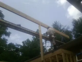 Carpenter setting a ridge beam over a new addition frame — Ice Dam Removal by Roofing Brothers in Martinez